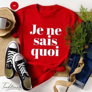 May include: Red t-shirt with white text that says "Je ne sais quoi".