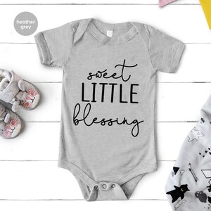 a baby bodysuit with the words sweet little blessing on it