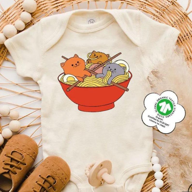 a baby bodysuit with a picture of two cats in a bowl