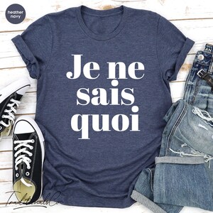 May include: A heather navy blue t-shirt with the French phrase "Je ne sais quoi" printed in white.