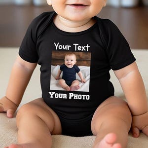 a baby sitting on top of a bed wearing a shirt
