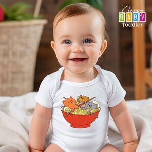 a baby sitting on a bed with a bowl of noodles