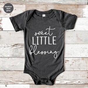 a black onesuit with the words sweet little blessing printed on it