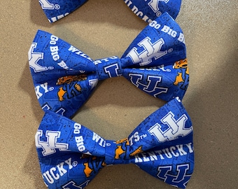 Może przedstawiać: Trzy niebieskie muszki z białym logo "UK" i nadrukowanymi napisami "Kentucky", "Wildcats" i "Go Big".