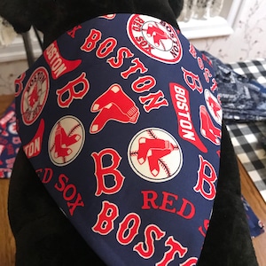 May include: A blue bandana with a red, white, and blue Boston Red Sox logo pattern. The bandana has the words "Boston Red Sox" repeated throughout the pattern.