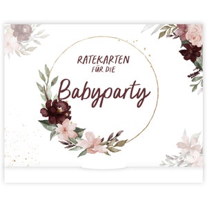 May include: A white card with a gold circle and burgundy floral design. The text "Ratekarten f&uuml;r die Babyparty" is inside the circle.