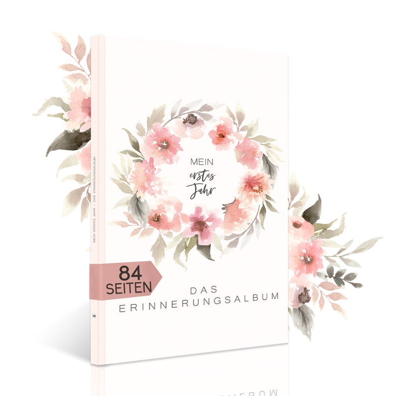 May include: A pink and white floral design with the text "Mein erstes Jahr" and "Das Erinnerungsalbum" on a white book cover. The book has 84 pages.