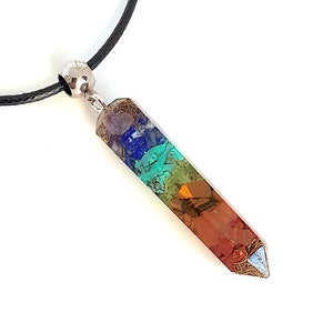 Peut inclure: Un collier avec un pendentif en cristal à sept chakras et un cordon noir. Le pendentif est un long cristal pointu avec sept couches de pierres de différentes couleurs, représentant les sept chakras.