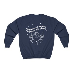 May include: Navy blue sweatshirt with a white graphic of hands holding a globe and the text "empowered women empower the planet".