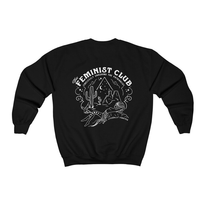 Może przedstawiać: Czarna bluza z białym nadrukiem przedstawiającym scenę z pustyni z tekstem "The Feminist Club Tirelessly Smashing The Patriarchy Since Literally Forever"