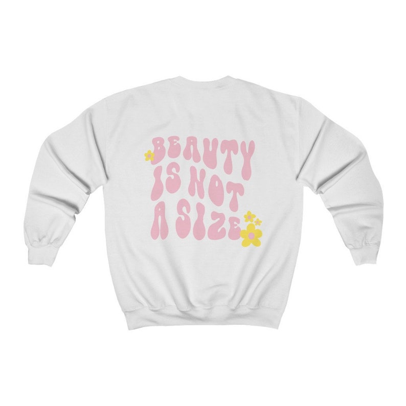 May include: White sweatshirt with the text "BEAUTY IS NOT A SIZE" in pink with yellow flowers.