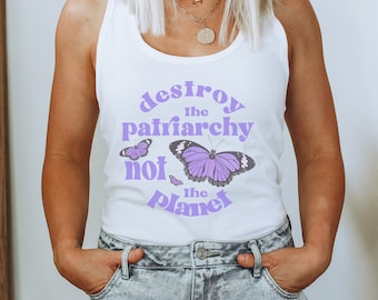 Puede incluir: Camiseta blanca de tirantes con el texto "destroy the patriarchy not the planet" en letras moradas. El texto está rodeado de mariposas moradas.