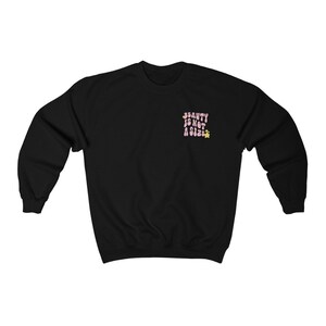 May include: Black sweatshirt with the text "BEAUTY IS NOT A SIZE" in pink letters with yellow flower accents.