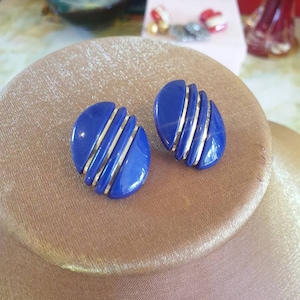 Earings 1980s clip on. Faceted blue acrylic in an oval shape, adorned with 3 gold lines.