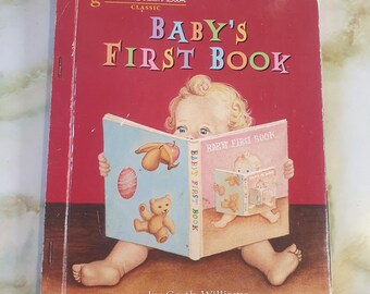 May include: A vintage "Baby's First Book" by Garth Williams. The cover is red with the title in orange and blue. The book is open, revealing illustrations of a teddy bear and a baby. The book is part of the "a Little Golden Book" series.