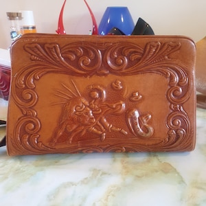 Shoulder bag, leather, 1980s. Made in Mexico by Nacho. Tooled leather depicting  bullfighting and flowers and Aztec style symbol.