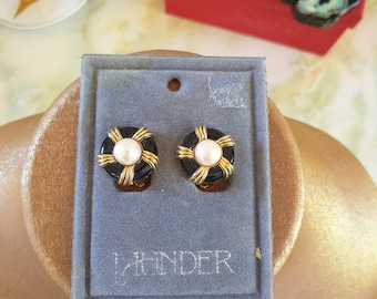 Earings clip on 1980s. Launder new/old stock, on original card. Goldtone in a circle shape, adorned with black enamel and a faux pearl.