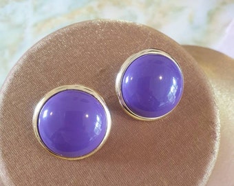 Earings 1980s clip ons. Goldtone in a circle shape, framing a purple acrylic dome centre.