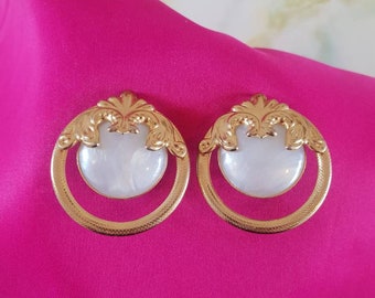 Earings 1980's clip on. Ornate goldtone surrounding a pale blue, lucite centre piece.