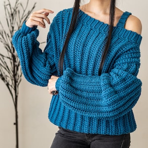 TCDDIY crochet pattern for a single strap sweater dress featuring balloon sleeves and a customizable length, crafted using Caron One Pound yarn in Ocean.
