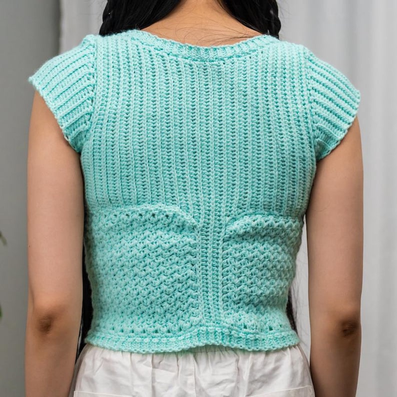 TCDDIY crochet pattern for a short sleeve cable stitch top with ribbing, featuring a Suzette stitch texture, made using Lion Brand Pound of Love yarn in Pastel Green, back view.