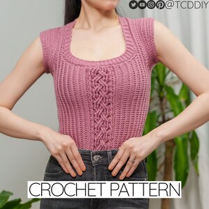Può includere: Un top rosa all'uncinetto con un motivo a treccia e una scollatura quadrata. Il top è senza maniche e ha una lunghezza corta. CROCHET PATTERN è scritto in bianco nella parte inferiore dell'immagine.