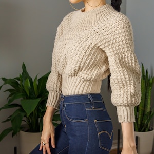 TCDDIY crochet pattern for a modern wide-collar Trinity stitch 3/4 sleeve sweater with a customizable fit, crafted using Baby Bernat Sport yarn in Baby Taupe, side view.
