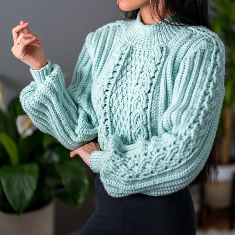 TCDDIY crochet pattern for a cropped cable stitch sweater with a mock neck and alpine stitch detailing, crafted using Caron One Pound yarn in Pale Green.