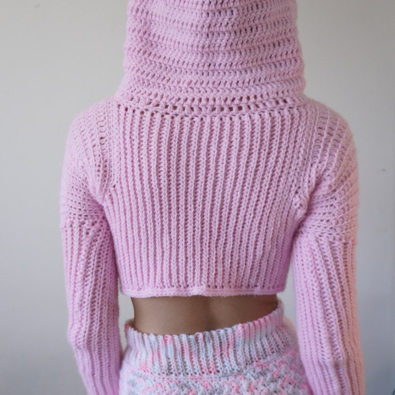 TCDDIY crochet pattern for a Long Sleeve Cropped Hoodie with thumbhole cuffs, ribbed sleeves, crafted using Lion Brand Pound of Love yarn in Pastel Pink, back view hood up.
