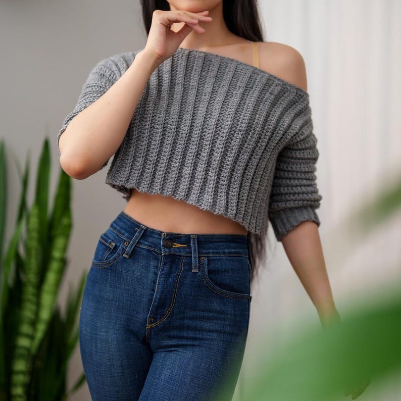 TCDDIY crochet pattern for an Off-the-Shoulder Cropped Sweater featuring short sleeves, ribbing, and open hem design, crafted with Lion Brand Pound of Love in Oxford Grey.