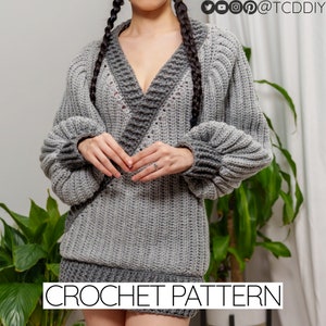 May include: A gray crochet sweater with a V-neck and long sleeves. The sweater has a contrasting dark gray trim around the neckline and cuffs. The sweater is shown on a model with a plant in the background. CROCHET PATTERN is written in white text at the bottom of the image.