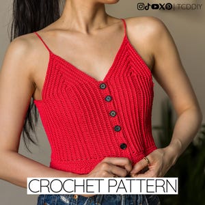May include: A bright red crochet crop top featuring thin spaghetti straps, a V-neckline, and a vertical row of five black buttons down the center. The garment has a ribbed texture throughout and is labeled with the text CROCHET PATTERN.