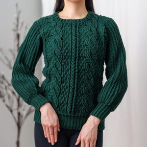 TCDDIY crochet pattern for a classic cropped crewneck sweater featuring cable and alpine stitches with ribbing details, made using Big Twist Soft yarn in Hunter Green.