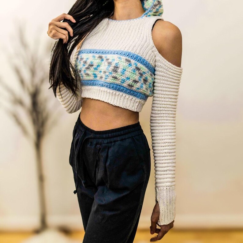 TCDDIY crochet pattern for a cold shoulder cropped hoodie with herringbone hood and thumbholes, crafted using Baby Bernat Sport yarn in White, Cool Blue, and Baby Blue.