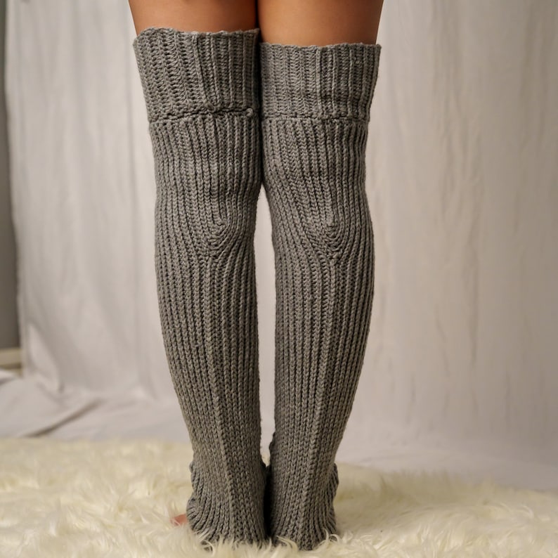 TCDDIY crochet pattern for Cable Stitch Leg Warmers featuring Alpine stitch detail and a knee-high fit, crafted using Caron One Pound yarn in Soft Grey Mix, back view.