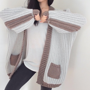 TCDDIY crochet pattern for an Oversized Reversible Cardigan featuring a ribbed two-toned design, pockets, crafted using Lion Brand Pound of Love yarn in Elephant Grey and Taupe.