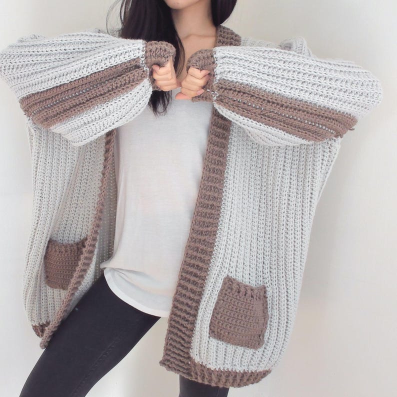 TCDDIY crochet pattern for an Oversized Reversible Cardigan featuring a ribbed two-toned design, pockets, crafted using Lion Brand Pound of Love yarn in Elephant Grey and Taupe.
