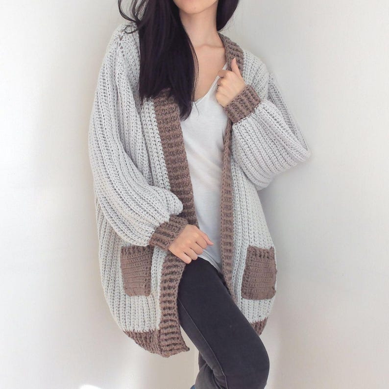 TCDDIY crochet pattern for an Oversized Reversible Cardigan featuring a ribbed two-toned design, pockets, crafted using Lion Brand Pound of Love yarn in Elephant Grey and Taupe.