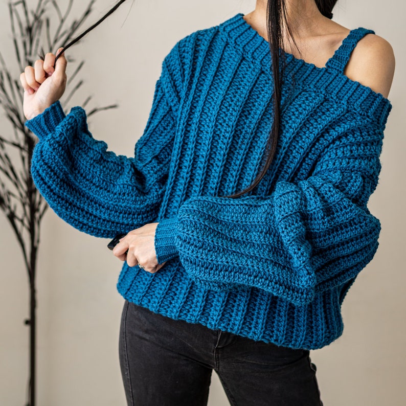 TCDDIY crochet pattern for a single strap sweater dress featuring balloon sleeves and a customizable length, crafted using Caron One Pound yarn in Ocean.