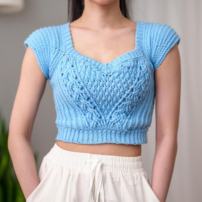 TCDDIY crochet pattern for a sweetheart cable stitch cropped T-shirt top with alpine stitch and ribbed detailing, crafted using Caron One Pound yarn in Pastel Blue.
