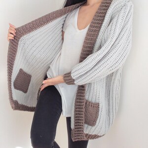 TCDDIY crochet pattern for an Oversized Reversible Cardigan featuring a ribbed two-toned design, pockets, crafted using Lion Brand Pound of Love yarn in Elephant Grey and Taupe.