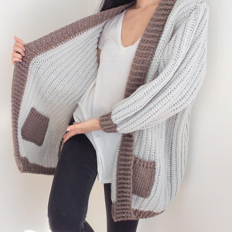 TCDDIY crochet pattern for an Oversized Reversible Cardigan featuring a ribbed two-toned design, pockets, crafted using Lion Brand Pound of Love yarn in Elephant Grey and Taupe.