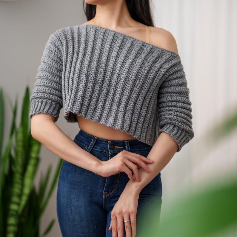 TCDDIY crochet pattern for an Off-the-Shoulder Cropped Sweater featuring short sleeves, ribbing, and open hem design, crafted with Lion Brand Pound of Love in Oxford Grey.