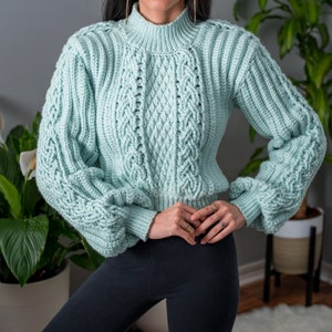 TCDDIY crochet pattern for a cropped cable stitch sweater with a mock neck and alpine stitch detailing, crafted using Caron One Pound yarn in Pale Green.
