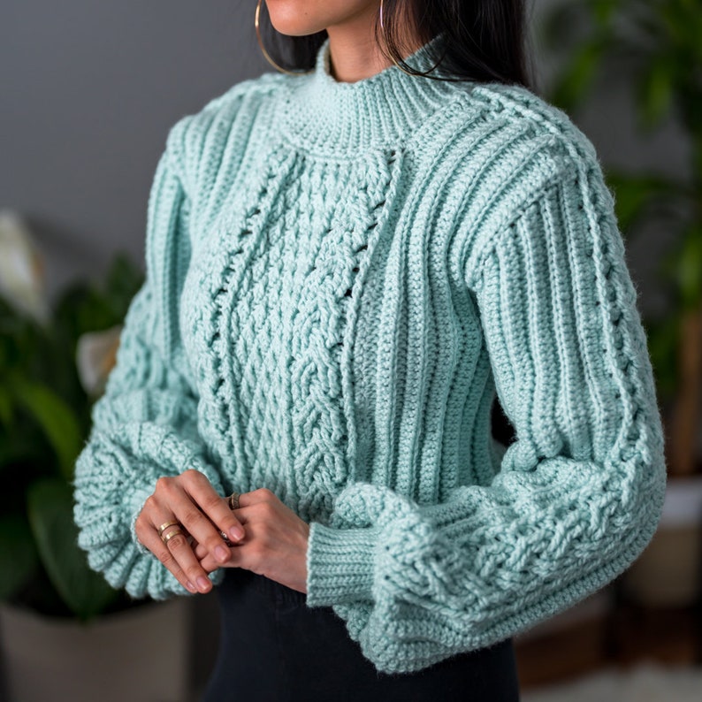 TCDDIY crochet pattern for a cropped cable stitch sweater with a mock neck and alpine stitch detailing, crafted using Caron One Pound yarn in Pale Green.