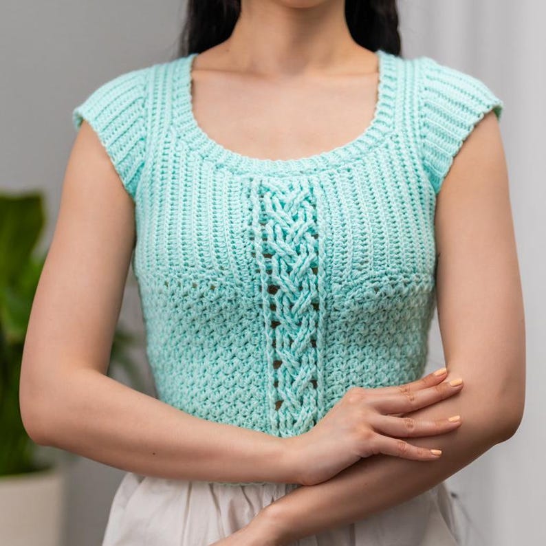 TCDDIY crochet pattern for a short sleeve cable stitch top with ribbing, featuring a cozy Suzette stitch texture, made using Lion Brand Pound of Love yarn in Pastel Green.