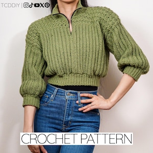Puede incluir: Un suéter verde tejido a crochet con cuello con cremallera y textura acanalada. El suéter tiene mangas tres cuartos y un corte cropped. Las palabras "CROCHET PATTERN" se muestran en texto blanco en la parte inferior de la imagen.