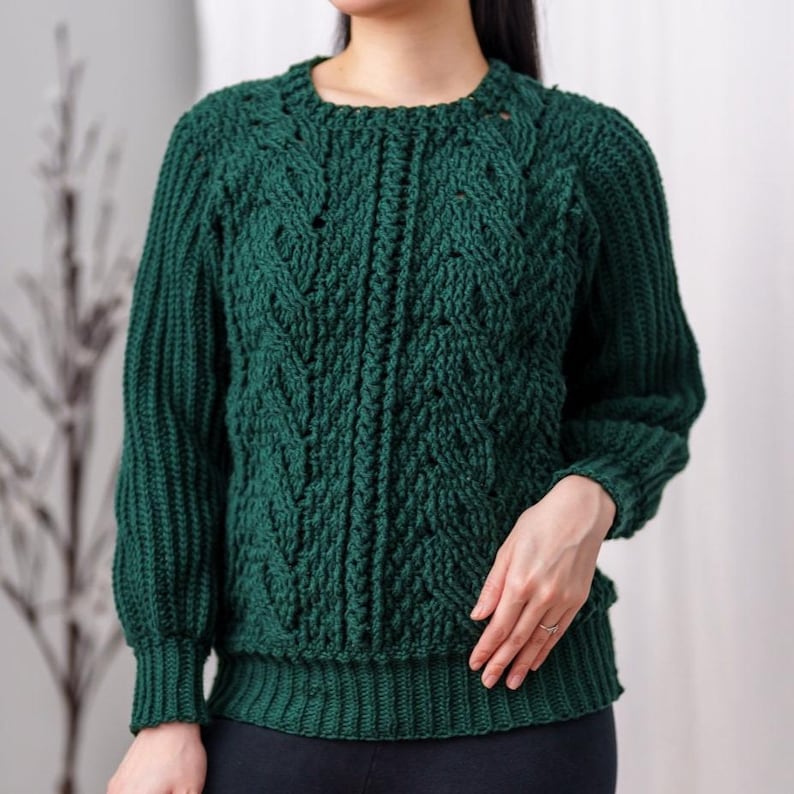 TCDDIY crochet pattern for a classic cropped crewneck sweater featuring cable and alpine stitches with ribbing details, made using Big Twist Soft yarn in Hunter Green.
