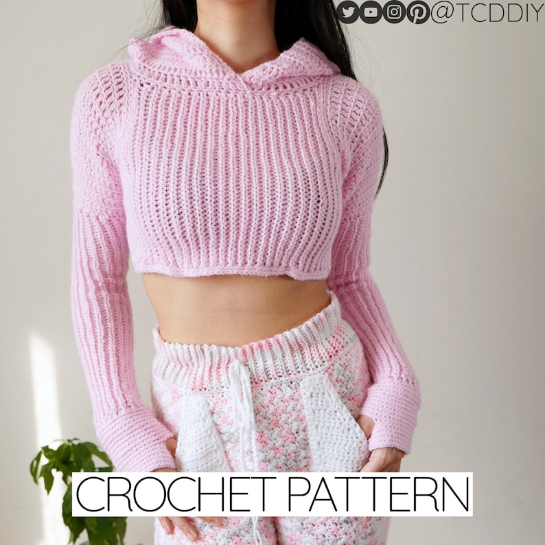 TCDDIY crochet pattern for a Long Sleeve Cropped Hoodie with thumbhole cuffs, ribbed sleeves, and customizable sizing, crafted using Lion Brand Pound of Love yarn in Pastel Pink.