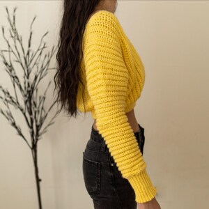 TCDDIY crochet pattern for a cropped off-the-shoulder V-neck sweater with versatile styling options, made with Lion Brand Pound of Love yarn in Honey Bee, side view.